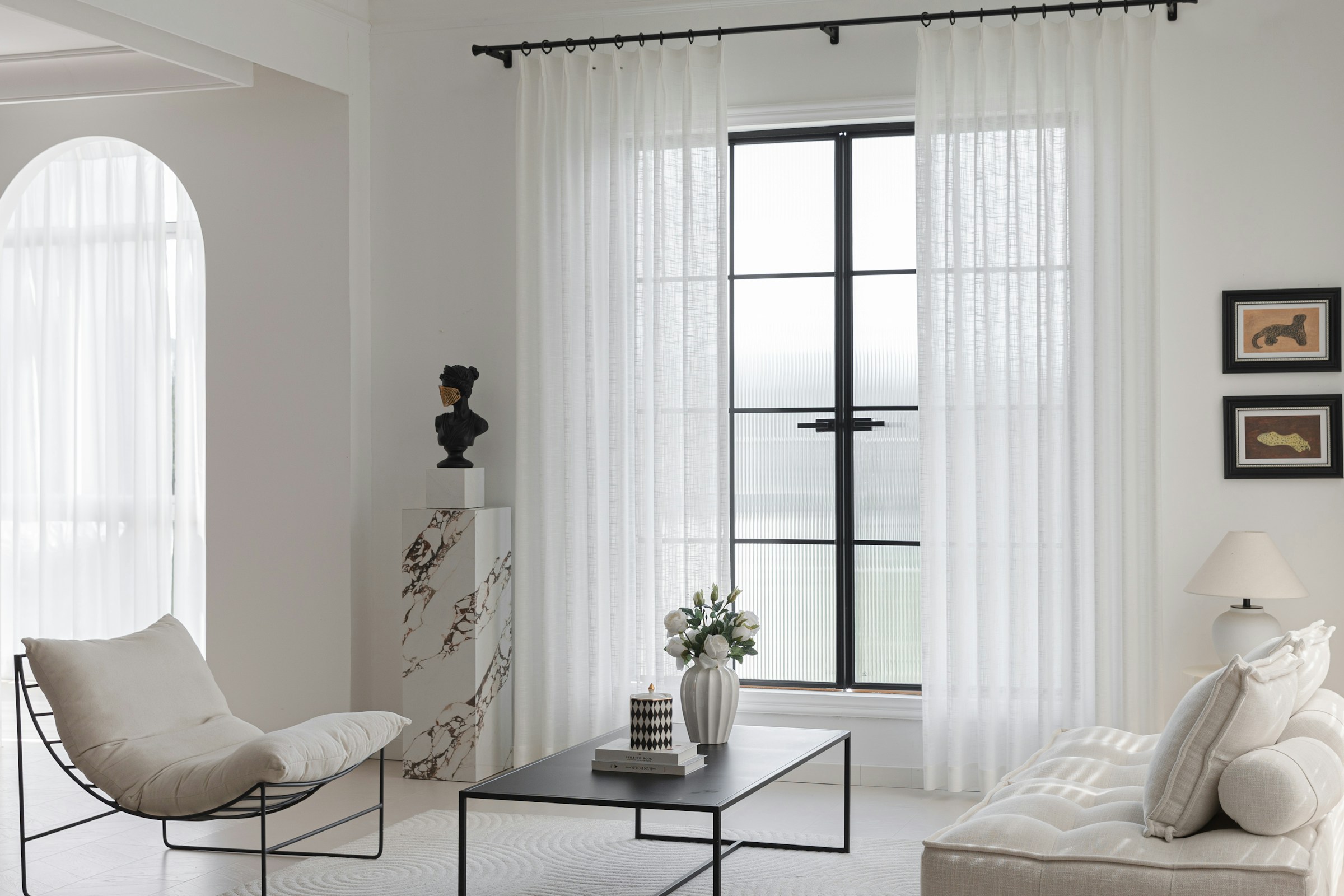 Contemporary living room with sheer white curtains and soft daylight